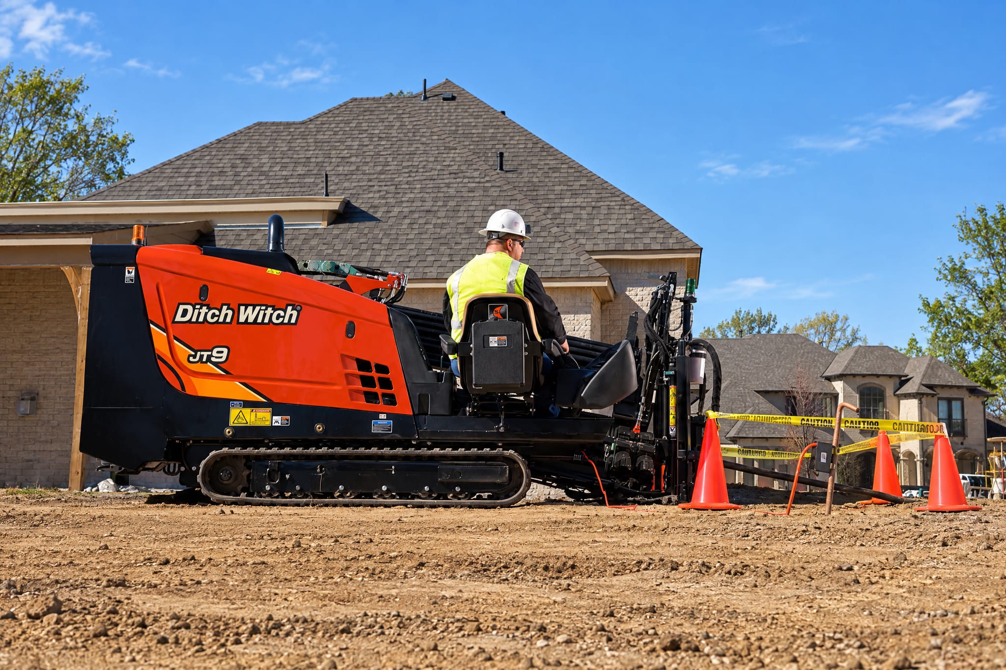 Ditch Witch JT9 directional drill and operator on a residential job site